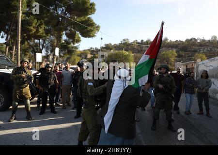 28. November 2021: Nablus, Palästina. 28. November 2021. Bewohner des Dorfes Lubban Ash-Sharqiya im Westjordanland konfrontieren israelische Soldaten, als sie sich aus Protest gegen die jüngsten täglichen Angriffe jüdisch-israelischer Siedler an der Schule des Dorfes versammeln. Das Dorf und die Schule wurden kürzlich von israelischen Siedlern angegriffen, die den Schülern den Zugang zur Schule versperrten und die palästinensische Gemeinschaft unter den Augen der israelischen Streitkräfte einschüchterten. Jüdisch-israelische Siedlungen im Westjordanland und in Ostjerusalem expandieren weiter, obwohl sie einen Verstoß gegen das Völkerrecht darstellen (Credit IMA Stockfoto