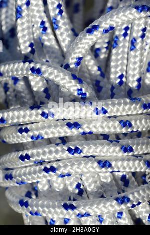 Nahaufnahme und Detailansicht eines gewickelten Kunststoffseils mit weißen und blauen Fasern Stockfoto