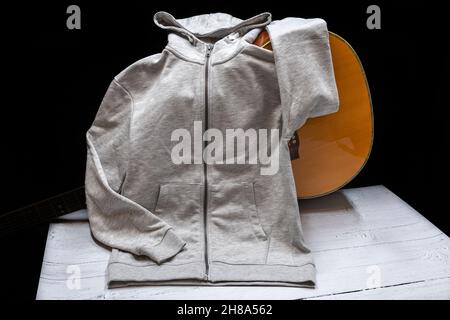 Ein grauer Unisex-Hoodie mit Fronttaschen und Kapuze und durchgehendem Reißverschluss vorne am Kleidungsstück Stockfoto