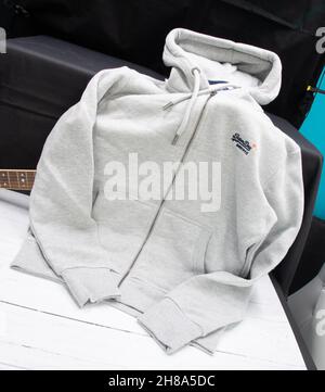 Irvine, Schottland, UK - 16. November 2021: Ein super trockener Unisex Hoodie in grauer Farbe mit Fronttaschen und Kapuze und durchgehendem Reißverschluss vorne Stockfoto