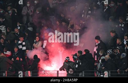 25. November 2021, Hessen, Frankfurt/Main: Fußball: Europa League, Eintracht Frankfurt - FC Royal Antwerpen, Gruppenphase, Gruppe D, Matchday 5 im Deutsche Bank Park. Ein Feuerwerk (Bengalo), das von Fans des Königlichen Antwerpen geworfen wird, brennt zwischen den Zuschauern in der gegnerischen Tribüne nieder. Ein Zuschauer wird verletzt. Foto: Arne Dedert/dpa Stockfoto