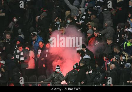 25. November 2021, Hessen, Frankfurt/Main: Fußball: Europa League, Eintracht Frankfurt - FC Royal Antwerpen, Gruppenphase, Gruppe D, Matchday 5 im Deutsche Bank Park. Ein Feuerwerk (Bengalo), das von Fans des Königlichen Antwerpen geworfen wird, brennt zwischen den Zuschauern in der gegnerischen Tribüne nieder. Ein Zuschauer wird verletzt. Foto: Arne Dedert/dpa Stockfoto