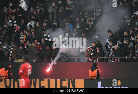 25. November 2021, Hessen, Frankfurt/Main: Fußball: Europa League, Eintracht Frankfurt - FC Royal Antwerpen, Gruppenphase, Gruppe D, Matchday 5 im Deutsche Bank Park. Ein Feuerwerk (Bengalo), das von Fans der königlichen Stadt Antwerpen geworfen wird, wird von Zuschauern auf den Tribünen weggeworfen. Ein Zuschauer wird verletzt. Foto: Arne Dedert/dpa Stockfoto