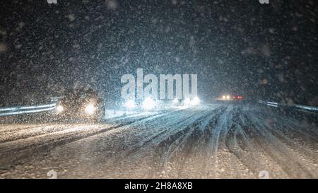 Stuttgart, Deutschland. 28th. November 2021. Autos fahren auf einer schneebedeckten Straße in dichter Schneegestöber. Quelle: Bernd Weißbrod/dpa/Alamy Live News Stockfoto