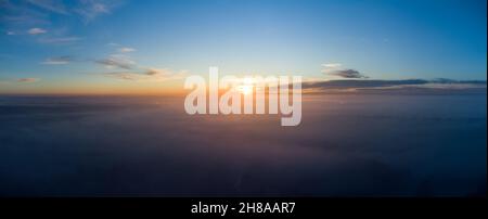Sonnenaufgang über dichtem Herbstnebel. Panorama über die Wolken am Morgen Stockfoto