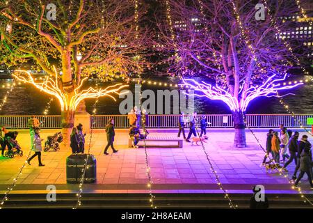 London, Großbritannien. 28th. November 2021. Die Londoner sitzen und spazieren auf den neonbeleuchteten Baumdächern, die dieses Jahr Teil der Southbank Winter Lights sind. Das kostenlose Display kann täglich von der Dämmerung bis zum 11,30pm. Januar bis zum 9th. Januar 2022 besichtigt werden. Kredit: Imageplotter/Alamy Live Nachrichten Stockfoto