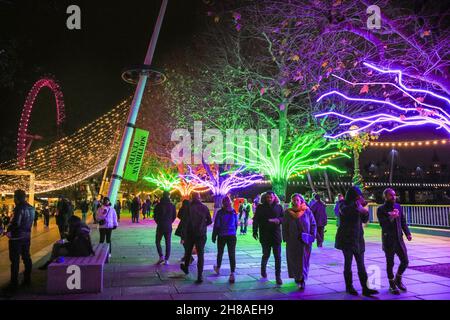 London, Großbritannien. 28th. November 2021. Die Londoner sitzen und spazieren auf den neonbeleuchteten Baumdächern, die dieses Jahr Teil der Southbank Winter Lights sind. Das kostenlose Display kann täglich von der Dämmerung bis zum 11,30pm. Januar bis zum 9th. Januar 2022 besichtigt werden. Kredit: Imageplotter/Alamy Live Nachrichten Stockfoto