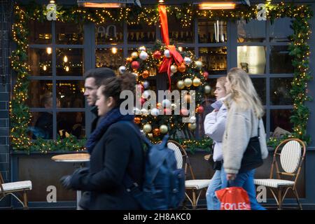 London, Großbritannien, 28. November 2021: Weihnachtseinkäufer unter den Weihnachtslichtern im West End von London. Trotz der Besorgnis über die neue Variante des Coronavirus und die bevorstehende Verhängung strengerer Maskenregeln in England ab Dienstag war der Köder von London an einem sonnigen Sonntagnachmittag für Käufer attraktiv, die hofften, ein Schnäppchen aus den noch laufenden Angeboten des Black Friday zu ergattern. Anna Watson/Alamy Live News Stockfoto