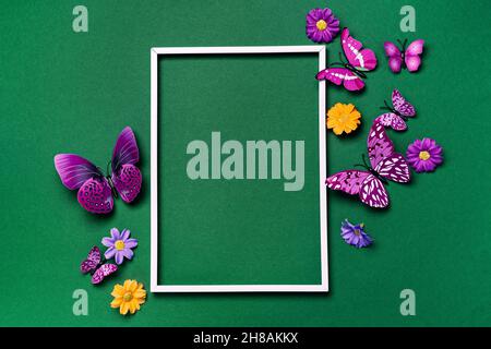 Imitierter Rahmen mit violetten Schmetterlingen auf Grün Stockfoto