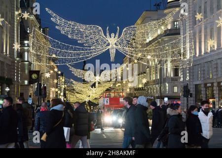 London, Großbritannien, 28. November 2021: Weihnachtseinkäufer unter den Weihnachtslichtern der Regent Street und des Picadilly Circus im West End von London. Trotz der Besorgnis über die neue Variante des Coronavirus und die bevorstehende Verhängung strengerer Maskenregeln in England ab Dienstag war der Köder von London an einem sonnigen Sonntagnachmittag für Käufer attraktiv, die hofften, ein Schnäppchen aus den noch laufenden Angeboten des Black Friday zu ergattern. Anna Watson/Alamy Live News Stockfoto