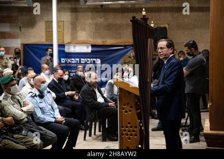 Der israelische Präsident Isaac Herzog zündet bei einer Zeremonie im Grab der Patriarchen, auch bekannt als Ibrahimi-Moschee, die erste Kerze der Chanukka an. Er ist der erste israelische Präsident, der an einer solchen Zeremonie im umstrittenen Kontext der geteilten Stadt Hebron teilnimmt. Linke Organisationen und Aktivisten, die versuchten, vor dem Ort gegen die Beteiligung von Herzog zu demonstrieren, wurden von der IDF und den Polizeikräften am Eingang zum nahe gelegenen Kiryat Arba angehalten - und protestierten am Eingang der Stadt. Hebron, Das Westjordanland. November 28th 2021. (Foto von Matan Golan/Sipa USA) Stockfoto