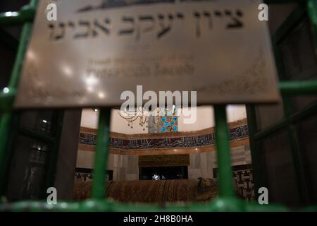 Hebron, Israel. 28th. November 2021. Der israelische Präsident Isaac Herzog zündet bei einer Zeremonie im Grab der Patriarchen, auch bekannt als Ibrahimi-Moschee, die erste Kerze der Chanukka an. Er ist der erste israelische Präsident, der an einer solchen Zeremonie im umstrittenen Kontext der geteilten Stadt Hebron teilnimmt. Kredit: Matan Golan/Alamy Live Nachrichten Stockfoto