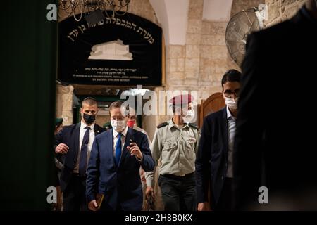 Hebron, Israel. 28th. November 2021. Der israelische Präsident Isaac Herzog zündet bei einer Zeremonie im Grab der Patriarchen, auch bekannt als Ibrahimi-Moschee, die erste Kerze der Chanukka an. Er ist der erste israelische Präsident, der an einer solchen Zeremonie im umstrittenen Kontext der geteilten Stadt Hebron teilnimmt. Kredit: Matan Golan/Alamy Live Nachrichten Stockfoto