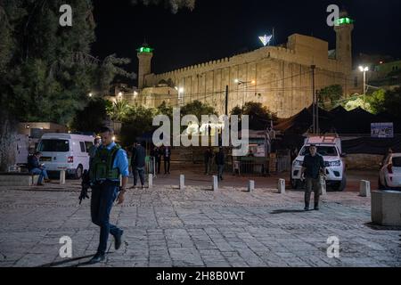 Hebron, Israel. 28th. November 2021. Der israelische Präsident Isaac Herzog zündet bei einer Zeremonie im Grab der Patriarchen, auch bekannt als Ibrahimi-Moschee, die erste Kerze der Chanukka an. Er ist der erste israelische Präsident, der an einer solchen Zeremonie im umstrittenen Kontext der geteilten Stadt Hebron teilnimmt. Kredit: Matan Golan/Alamy Live Nachrichten Stockfoto