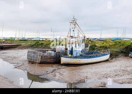 Traditionelle hölzerne Fischerboote wurden bei Ebbe auf Schlamm gesetzt, Brancaster Staithe, Nordküste von Norfolk, East Anglia, England Stockfoto