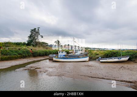 Traditionelle hölzerne Fischerboote wurden bei Ebbe auf Schlamm gesetzt, Brancaster Staithe, Nordküste von Norfolk, East Anglia, England Stockfoto