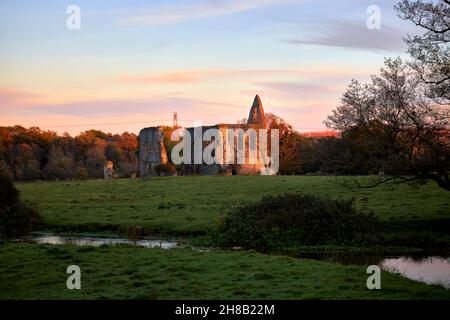Ruinen des Newark Priory, einem Augustiner-Priorat am Fluss Wey, einem planmäßigen Denkmal, in der Nähe von Ripley und Pyrford, Surrey, beleuchtet von der untergehenden Sonne Stockfoto