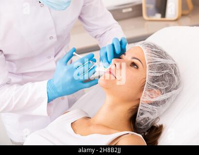 Frau erhält verjüngende Gesichts-Injektionen Stockfoto