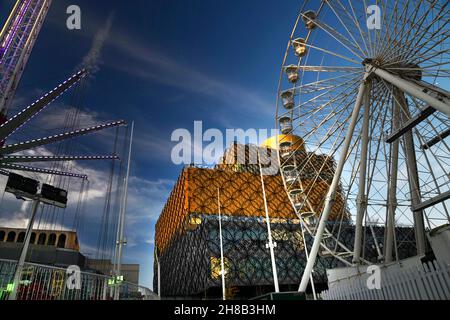 Wenn Weihnachten naht, besuchen die Menschen das moderne Bibliotheksdach, um die Aussicht zu genießen und am frühen Winterabend die Fahrten auf dem Messegelände in der Nähe zu genießen. Stockfoto