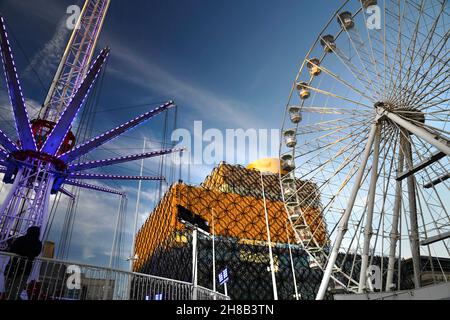 Wenn Weihnachten naht, besuchen die Menschen das moderne Bibliotheksdach, um die Aussicht zu genießen und am frühen Winterabend die Fahrten auf dem Messegelände in der Nähe zu genießen. Stockfoto