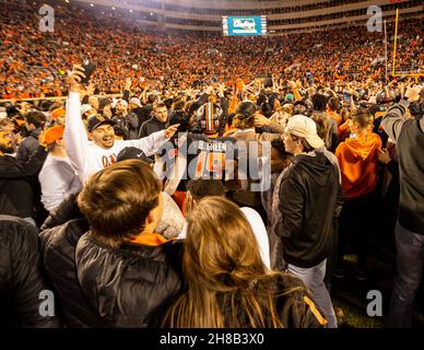 Stillwater, Oklahoma, USA. 27th. November 2021. Oklahoma State Cowboy-Fans stürzen sich nach dem Sieg über die Oklahoma Sooners aus dem Jahr 37-33 am Samstag, den 27. November 2021 im Boone Pickens Stadium in Stillwater, Oklahoma, ins Feld. (Bild: © Nichola Rutledge/ZUMA Press Wire) Stockfoto