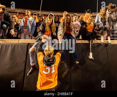 Stillwater, Oklahoma, USA. 27th. November 2021. Oklahoma State Cowboy-Fans stürzen sich nach dem Sieg über die Oklahoma Sooners aus dem Jahr 37-33 am Samstag, den 27. November 2021 im Boone Pickens Stadium in Stillwater, Oklahoma, ins Feld. (Bild: © Nichola Rutledge/ZUMA Press Wire) Stockfoto