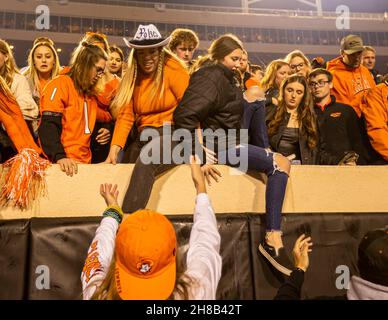 Stillwater, Oklahoma, USA. 27th. November 2021. Oklahoma State Cowboy-Fans stürzen sich nach dem Sieg über die Oklahoma Sooners aus dem Jahr 37-33 am Samstag, den 27. November 2021 im Boone Pickens Stadium in Stillwater, Oklahoma, ins Feld. (Bild: © Nichola Rutledge/ZUMA Press Wire) Stockfoto