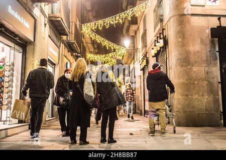Barcelona, Katalonien, Spanien. 26th. November 2021. Menschen, die in Barcelona entlang der Banys Nous Street spazieren, die von leuchtend gelben Weihnachtslichtern beleuchtet ist. (Bild: © Thiago Prudencio/SOPA Images via ZUMA Press Wire) Stockfoto