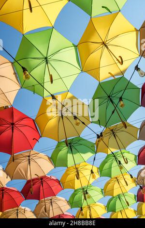 Bunte Sonnenschirme überstehen die Straße der Stadt Stockfoto