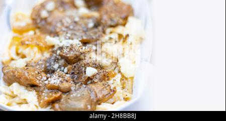 Fettuccine Pasta mit Steinpilzen und Parmesankäse. Köstliche italienische Pasta mit klarem Hintergrund. Stockfoto