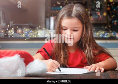 Das Mädchen schreibt den Brief an den Weihnachtsmann Stockfoto