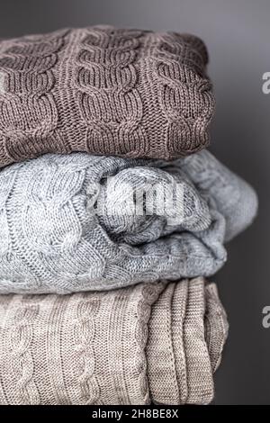 Nahaufnahme strukturierter Strickdecken in einem Stapel. Stockfoto