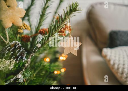 Geschmückter Weihnachtsbaum mit trockenen Blumen, Tannenzapfen und Holzstern. Boho-Design. Nahaufnahme. Stockfoto
