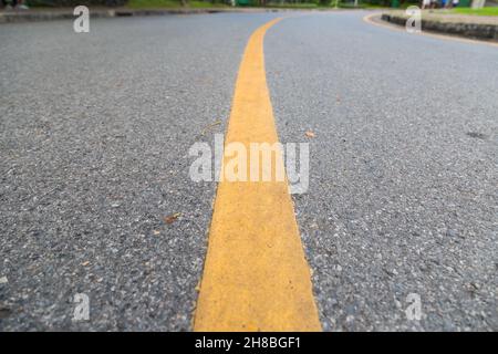 Nahaufnahme der gelben Linie auf dem öffentlichen Park mit Menschen Bewegung und Radfahren für eine gute Gesundheit Hintergrund Stockfoto