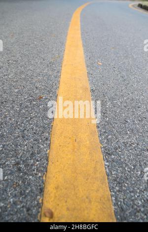 Nahaufnahme der gelben Linie auf dem öffentlichen Park mit Menschen Bewegung und Radfahren für eine gute Gesundheit Hintergrund Stockfoto
