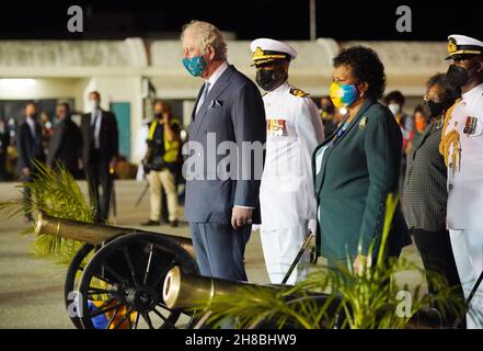 Der Prinz von Wales beobachtet bei seiner Ankunft am internationalen Flughafen Grantley Adams, Bridgetown, Barbados, einen Waffengruß, der neben Sandra Mason, der ehemaligen Generalgouverneurin und designierten Präsidentin von Barbados, steht. Bilddatum: Sonntag, 28. November 2021. Stockfoto