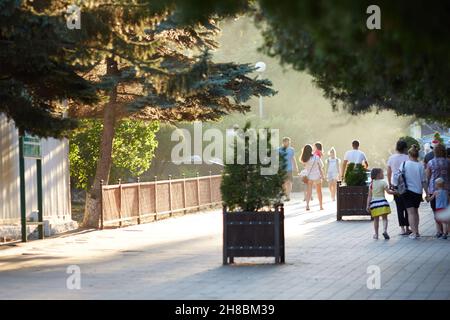 RUSSLAND, ANAPA - 23. august 2020 Menschen gehen an einem sonnigen Sommertag die Straße entlang. Eine Menschenmenge läuft im Park. Speicherplatz kopieren. Stockfoto