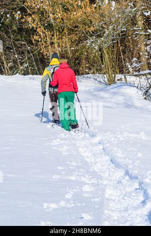 Zwei junge Leute wandern im Schnee mit Schneeschuhen Stockfoto