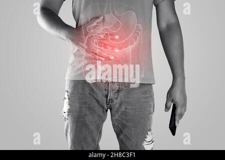 Die Darstellung der inneren Organe ist auf dem Körper des Mannes vor dem grauen Hintergrund zu sehen. Peopel berühren Magen schmerzhaft leiden an Enteritis. Interne Org Stockfoto
