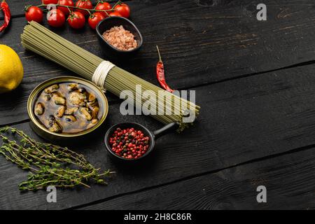 Rohe Pasta mit Sahnesauce, Muscheln und Parmesan Zutaten Set, auf schwarzem Holztisch Hintergrund, mit Platz für Text Stockfoto