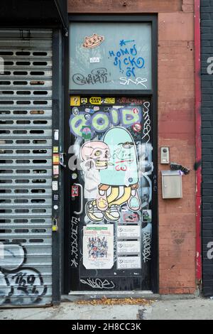 Eine Tür komplett mit Aufklebern, Street Art, Graffiti und Tags bedeckt. An der Bedford Ave. In Williamsburg, Brooklyn, New York. Stockfoto