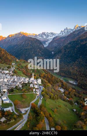 Luftaufnahme des kleinen Dorfes Soglio bei Sonnenuntergang im Herbst. Bezirk Maloja, Kanton Graubünden, Bregaglia-Tal, Schweiz, Europa. Stockfoto