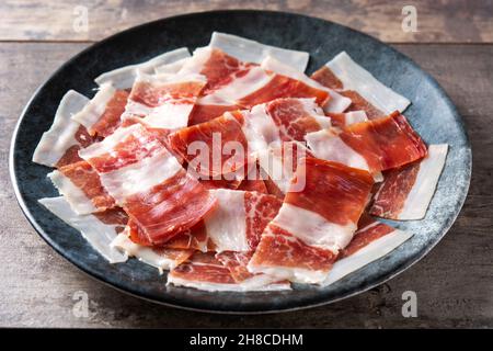 Spanish serrano Schinken Scheiben Teller auf Holztisch Stockfoto