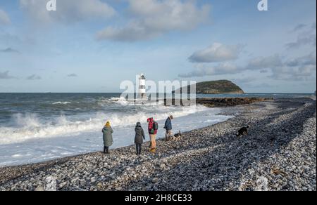 Die Familie genießt einen Spaziergang am Kiesstrand in Penmon, Anglesey, Wales Stockfoto