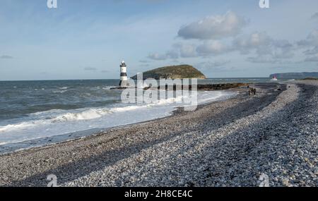 Die Familie genießt einen Spaziergang am Kiesstrand in Penmon, Anglesey, Wales Stockfoto