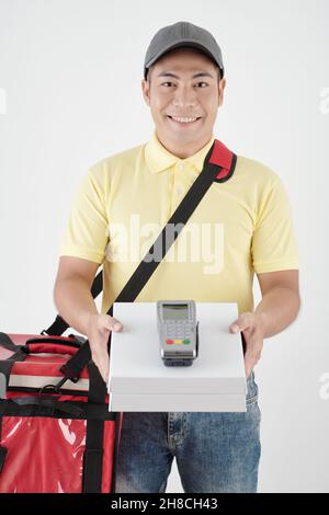 Fröhlicher Lieferer, der dem Kunden Boxen mit Pizza und Zahlungsterminal gab Stockfoto