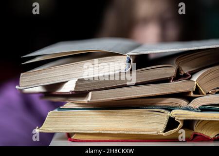 Nahaufnahme eines Stapels offener Bücher auf unscharfem Hintergrund. Stockfoto