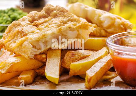 Traditionelle britische Street Food Fisch und Pommes mit Ketchup Soße auf Pergamentpapier Stockfoto