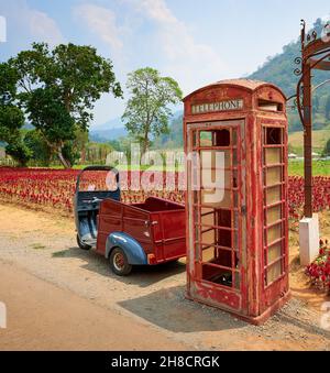 Vertikale Aufnahme einer alten Telefonzelle auf dem Land in Thailand Stockfoto