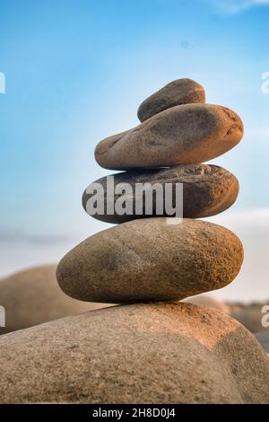 Ausgewogene Steine an einem Kiesstrand während des Sonnenuntergangs in Bangladesch. Stockfoto